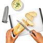 Hands using a knife to cut bread on a white cutting board. 