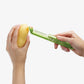 Person using a green potato peeler to peel a yellow potato on a white background.