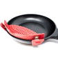 A red silicone pan lifter and handle cover attached to a black frying pan on a white background.