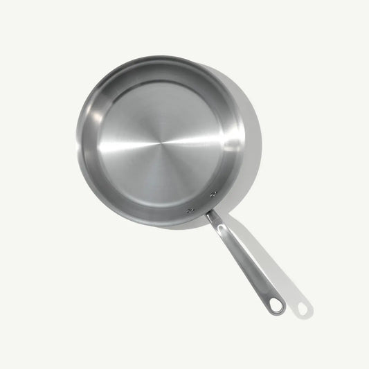 A top view of a stainless steel frying pan with a stay-cool handle.