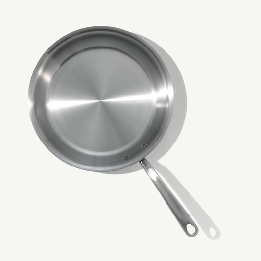 A top view of a stainless steel frying pan with a stay-cool handle.