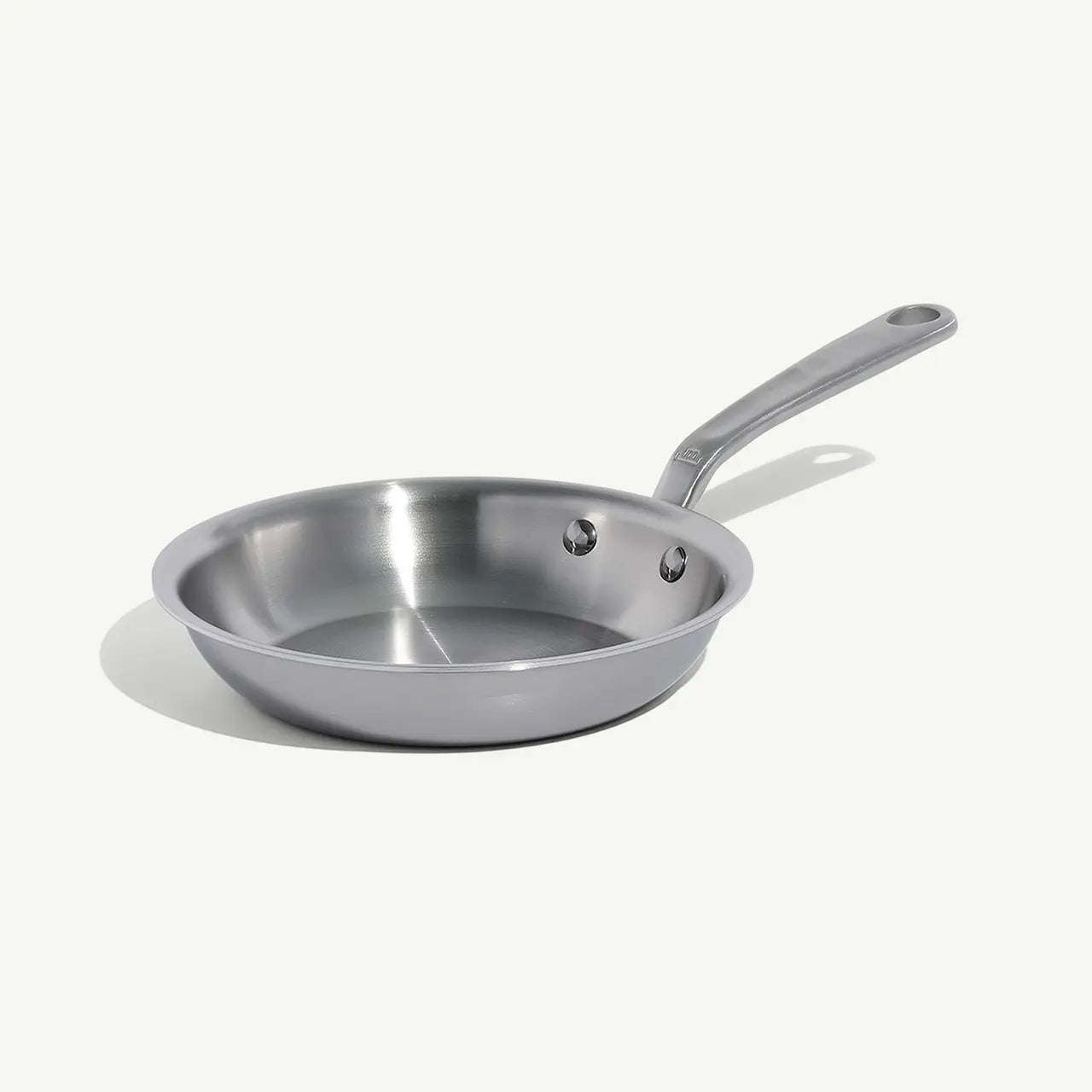A stainless clad frying pan with a stay-cool handle, suitable for gas, electric, and induction cooktops on a white background.