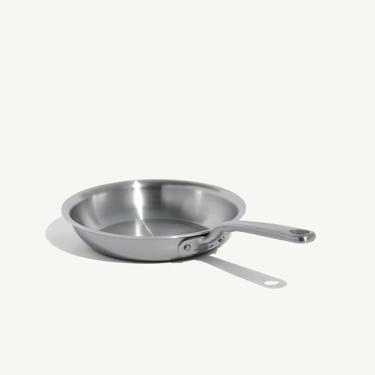 A stainless clad frying pan with a stay-cool handle, suitable for gas, electric, and induction cooktops on a white background.