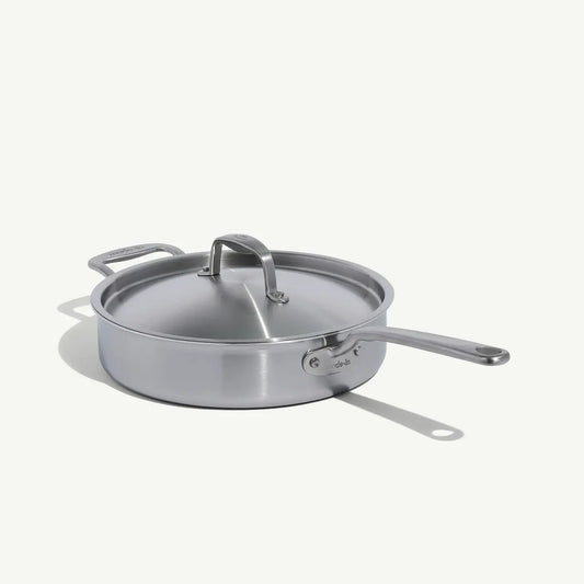 A stainless steel sauté pan with a lid and stay-cool handle, on a white background.