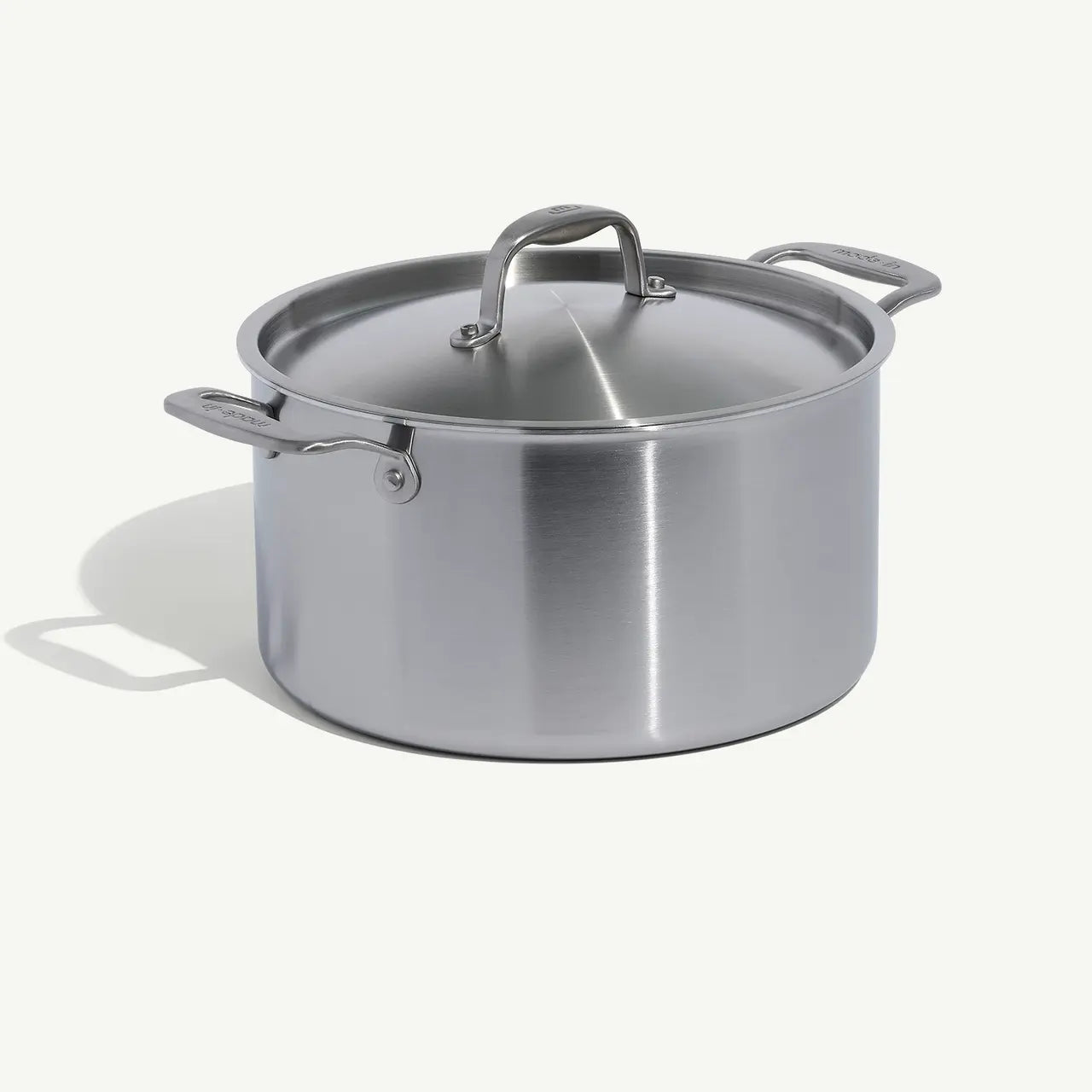 A silver stainless clad stock pot with lid, featuring two handles and a fitted lid, on a white background.