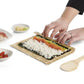 Person making sushi with bamboo mat on a white background