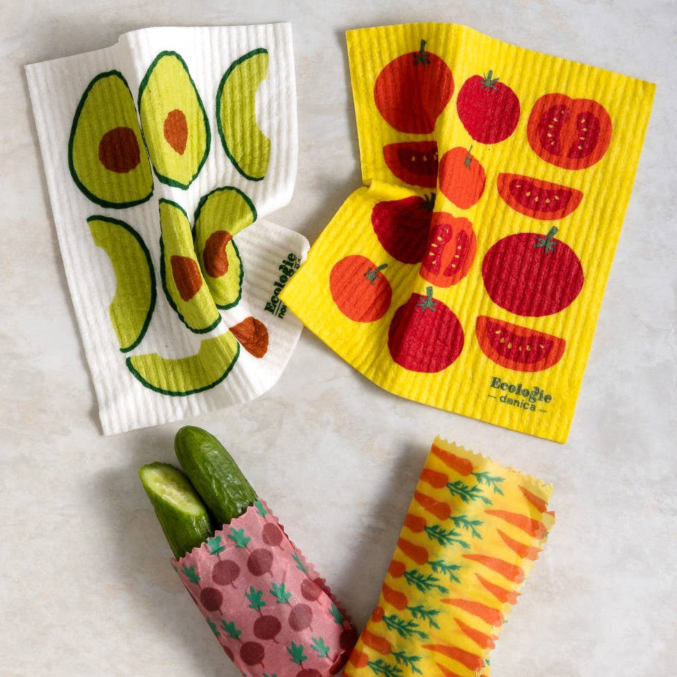 Set of reusable food wraps with avocado, apple, and cucumber designs on a light gray background.