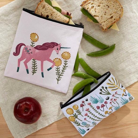 Set of two reusable snack bags featuring a pink unicorn on the larger food bag and a sweet flower pattern on the smaller food bag.  Both bags have food safe lining making these snack bags good to last all school year and beyond!