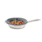 Stainless steel frying pan with a lid containing food on a white background