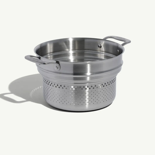 A stainless steel pasta insert with slotted holes designed to fit into a stock pot for cooking pasta on a white background.