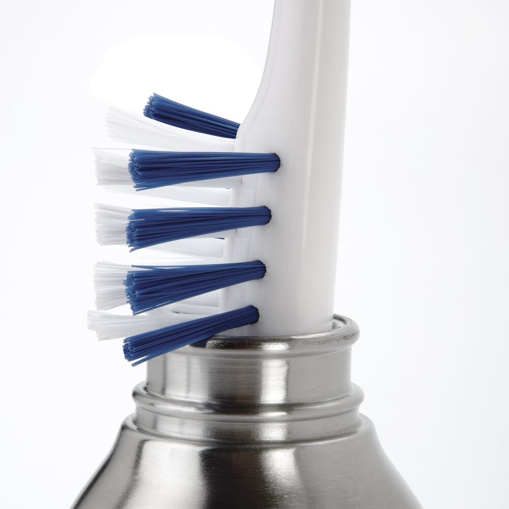 Blue brisseled brush being used to clean a metal water bottle. 