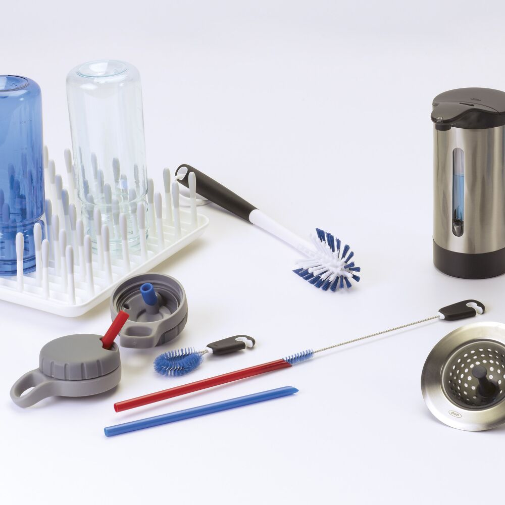 Multple bottle brushes, soap and bottleson a white surface. 