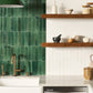 Modern kitchen with green tiled wall, wooden shelves, and various kitchen items.