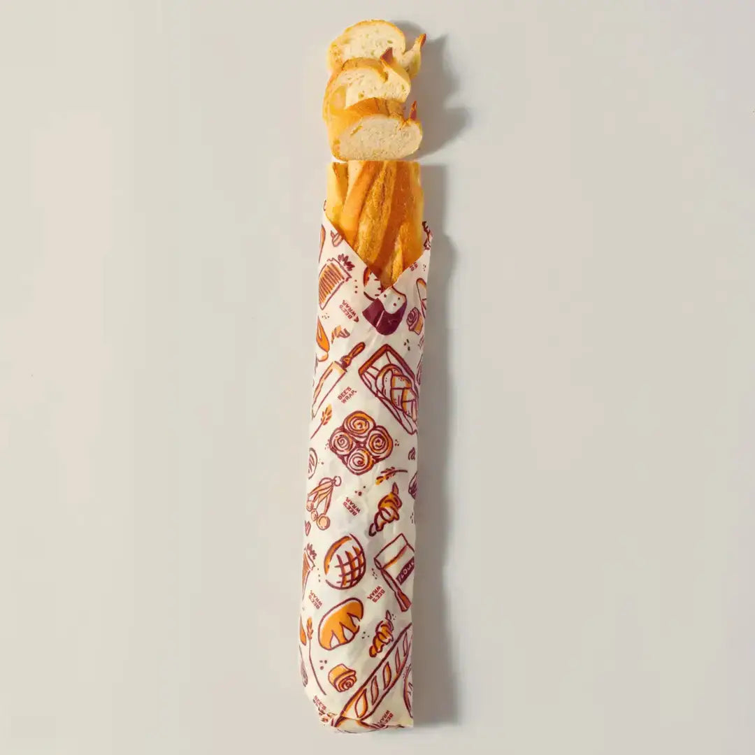 Baguette wrapped in a patterned paper on a light gray background