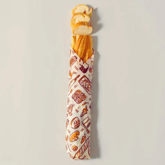 Baguette wrapped in a patterned paper on a light gray background