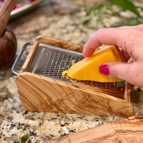 olive wood cheese grater being used with cheese