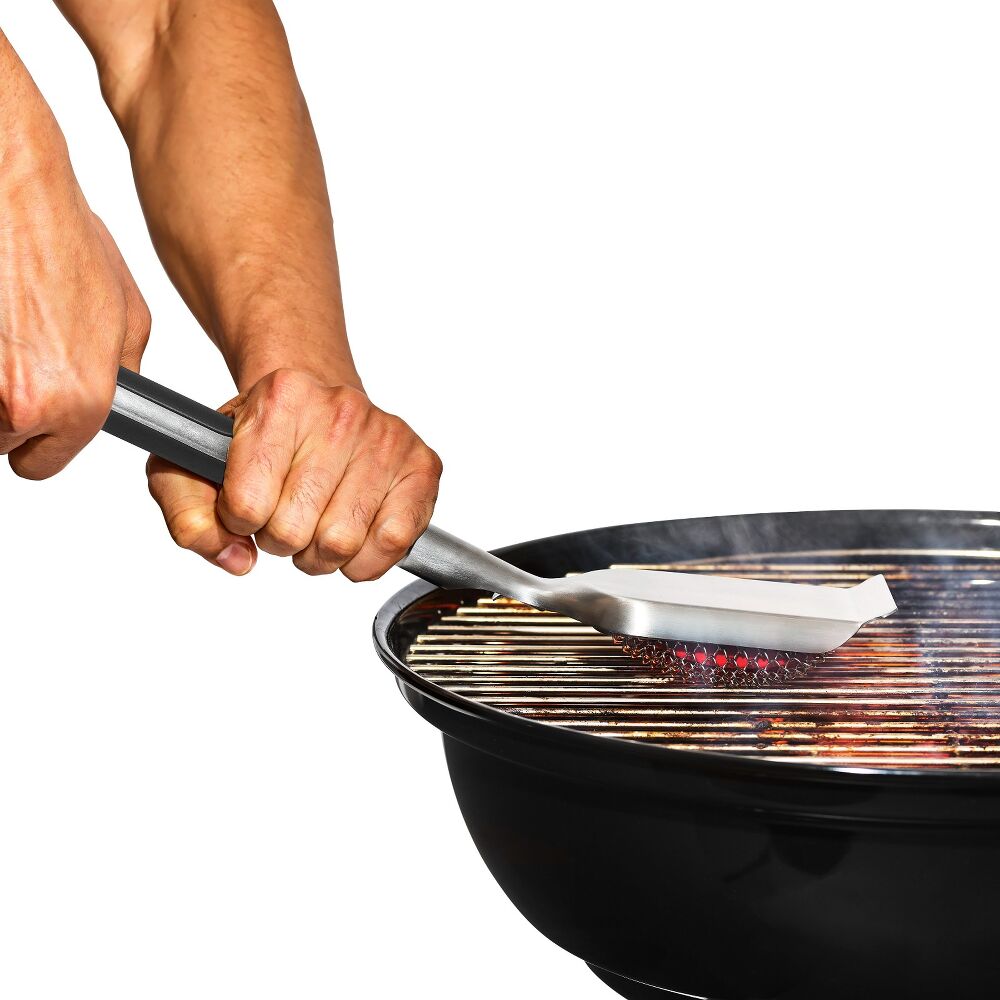 Person using tongs to cook food on a grill with a white background