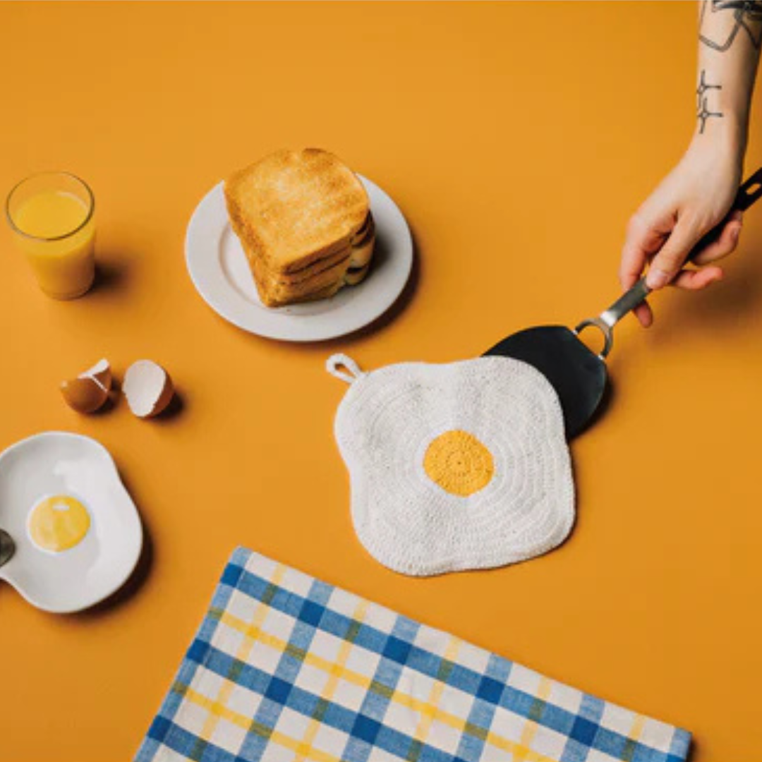 Add a playful touch to your kitchen with the Crochet Egg Trivet, a delightful blend of fun and function. Handmade with care, this 100% cotton trivet is inspired by our joyful collections, bringing warmth and personality to your cooking space. 