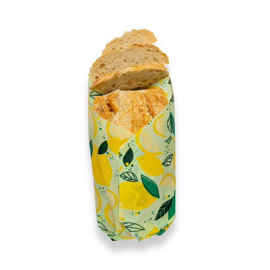 Bread loaf wrapped in a lemon-patterned wrap on a white background
