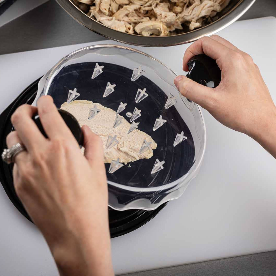Person preparing food on a cutting board with a container of ingredients.