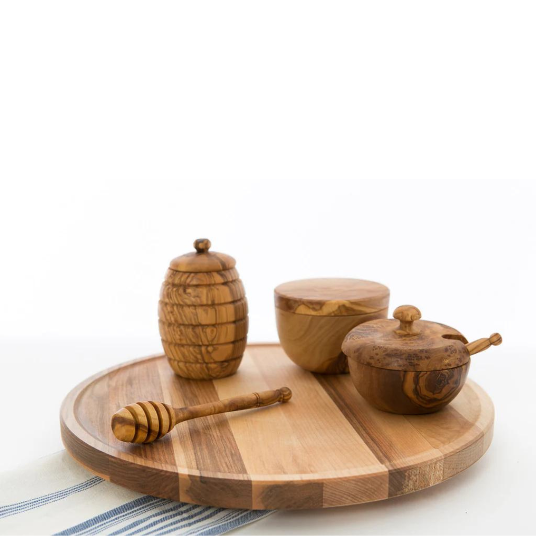 olive wood honey dipper on tray with other olive wood tools