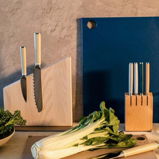 Material Brand Cutting Board made from recycled material in lapis blue on a counter with vegetables