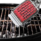 Barbecue grill cleaning brush with red bristle head on a grill