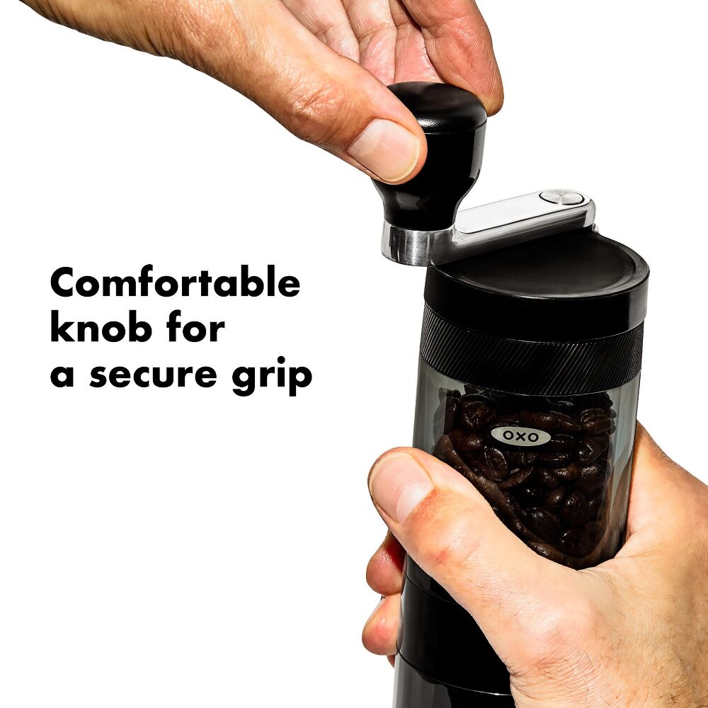 Hand holding a black OXO coffee grinder with text 'Comfortable knob for a secure grip'.