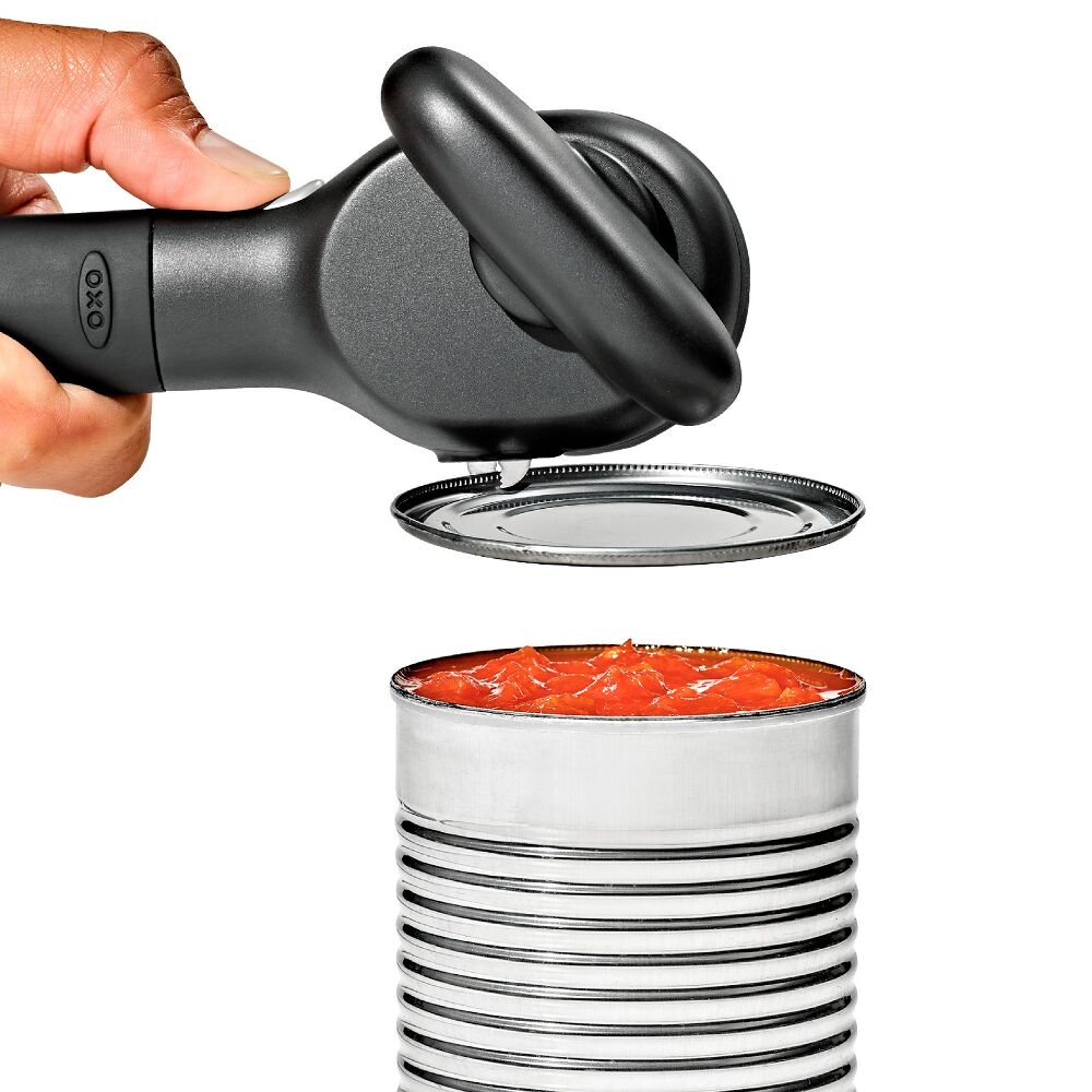 Can opener being used on a can of food with a white background
