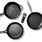 Set of black cookware including skillets and a scrubber on a white background