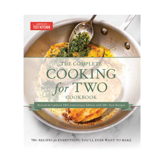 Cookbook titled 'The Complete Cooking for Two Cookbook' by American Test Kitchen with a dish on a pan.