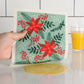 Embrace the classic Christmas spirit with the Poinsettia Swedish Sponge Cloth by Ecologie! Decked out in vibrant red poinsettias, this festive dishcloth adds a burst of holiday cheer to every clean-up task. 