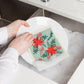 Embrace the classic Christmas spirit with the Poinsettia Swedish Sponge Cloth by Ecologie! Decked out in vibrant red poinsettias, this festive dishcloth adds a burst of holiday cheer to every clean-up task. 